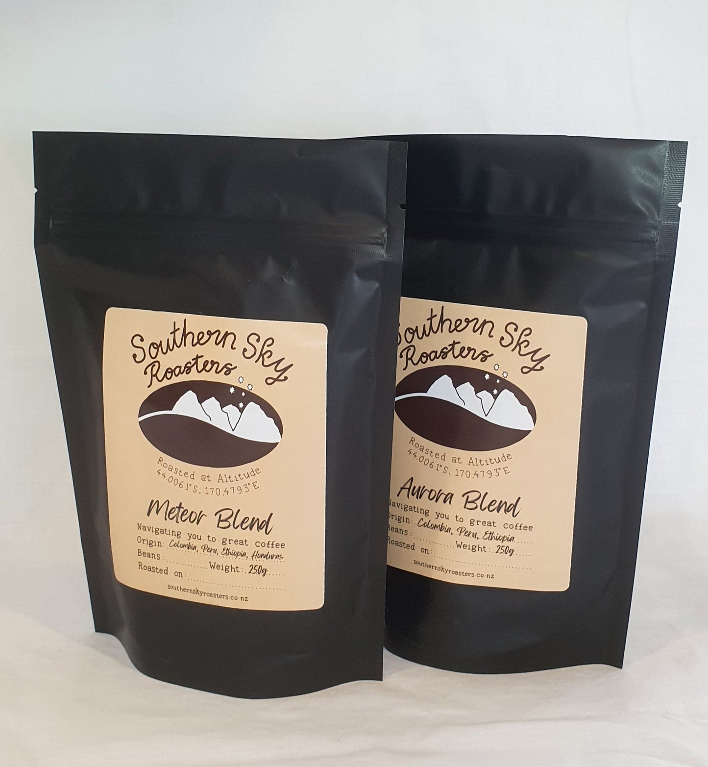 Two bags of coffee, both labelled 'Southern Sky Roasters' with 'Aurora Blend' & "Meteor Blend" written on them. The Aurora Blend is a blend of beans from Colombia, Peru and Ethiopia. The Meteor Blend is a blend of beans from Honduras, Peru, Colombia & Ethiopia. The black bags contain 250g of coffee.
Southern Sky Roasters
Artisan Roastery Lake Tekapo, New Zealand
Coffee 
Southern Sky Roasters
Organic coffee
Artisan Roastery
Meteor Blend and Aurora Blend
Lake Tekapo New Zealand